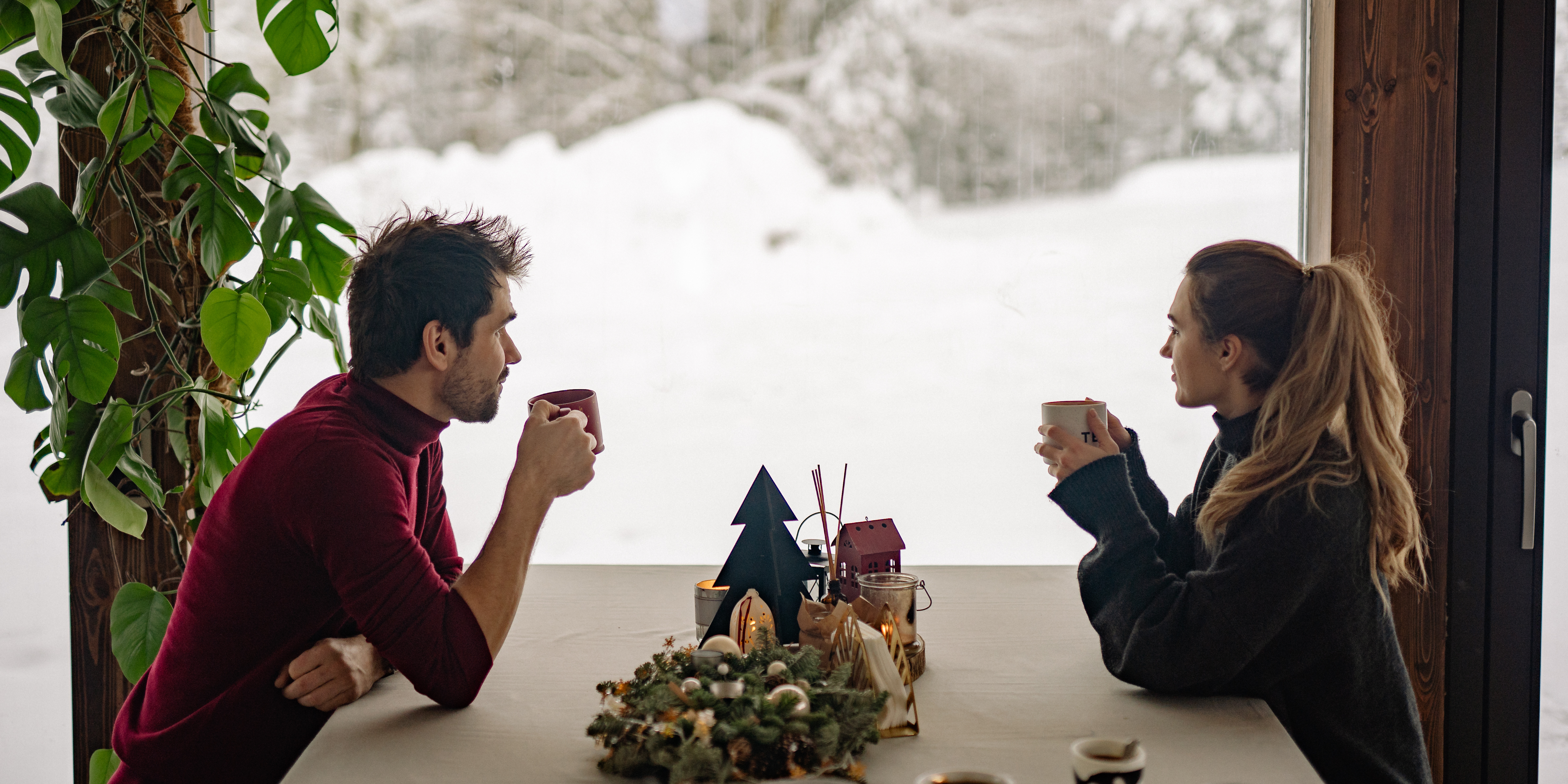 Separated couple sitting across from each other during the holidays, representing co-parenting and navigating divorce during holiday seasons