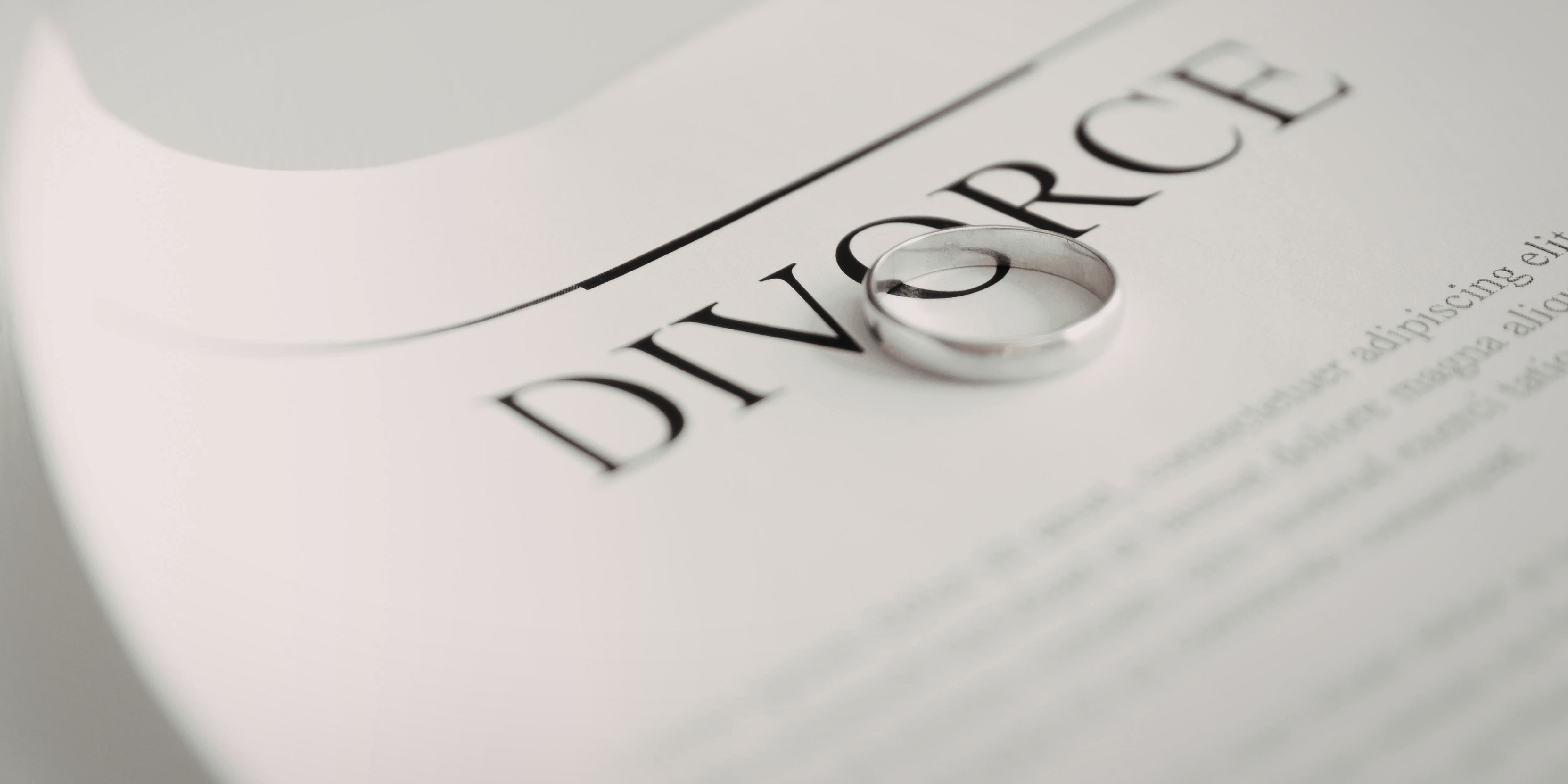 Close-up of a divorce document with wedding rings, representing divorce proceedings and quick or flat fee divorce options