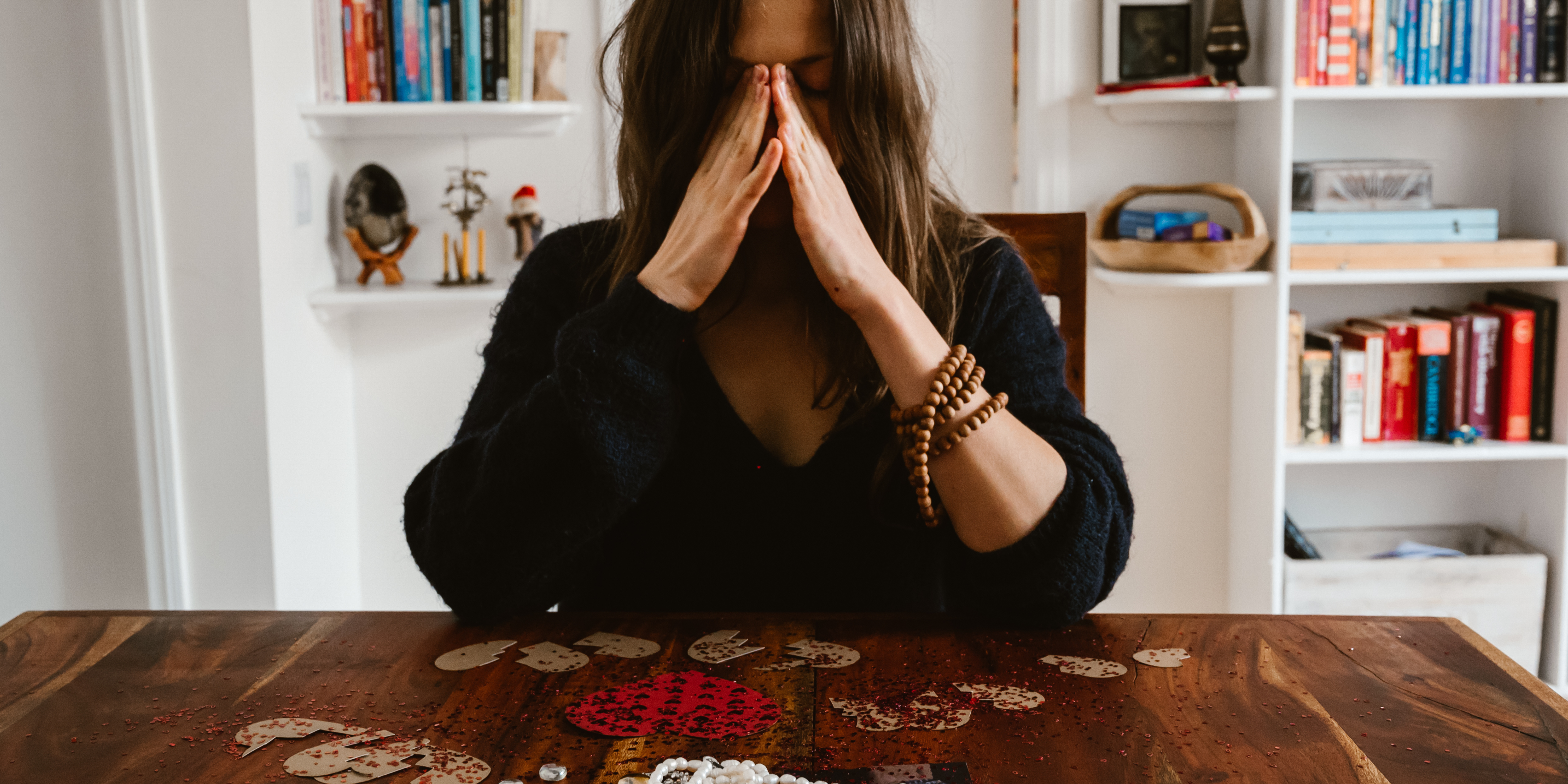 Person sitting at a table with hands clasped, reflecting emotional loss of extended family and friendships after divorce