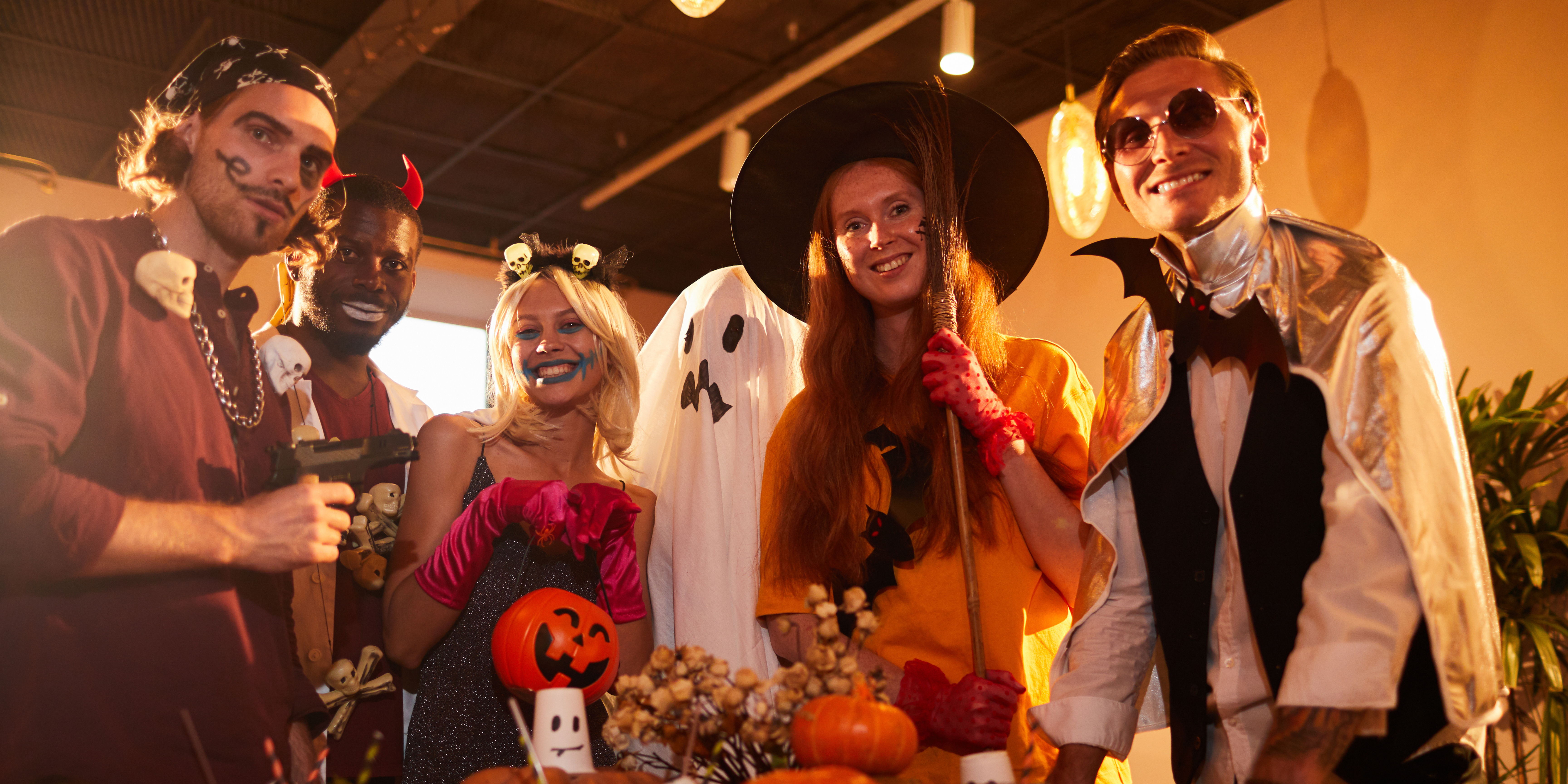 Group of adults dressed in creative Halloween costumes smiling at a party, symbolizing confidence, humor, and self-expression during or after divorce.