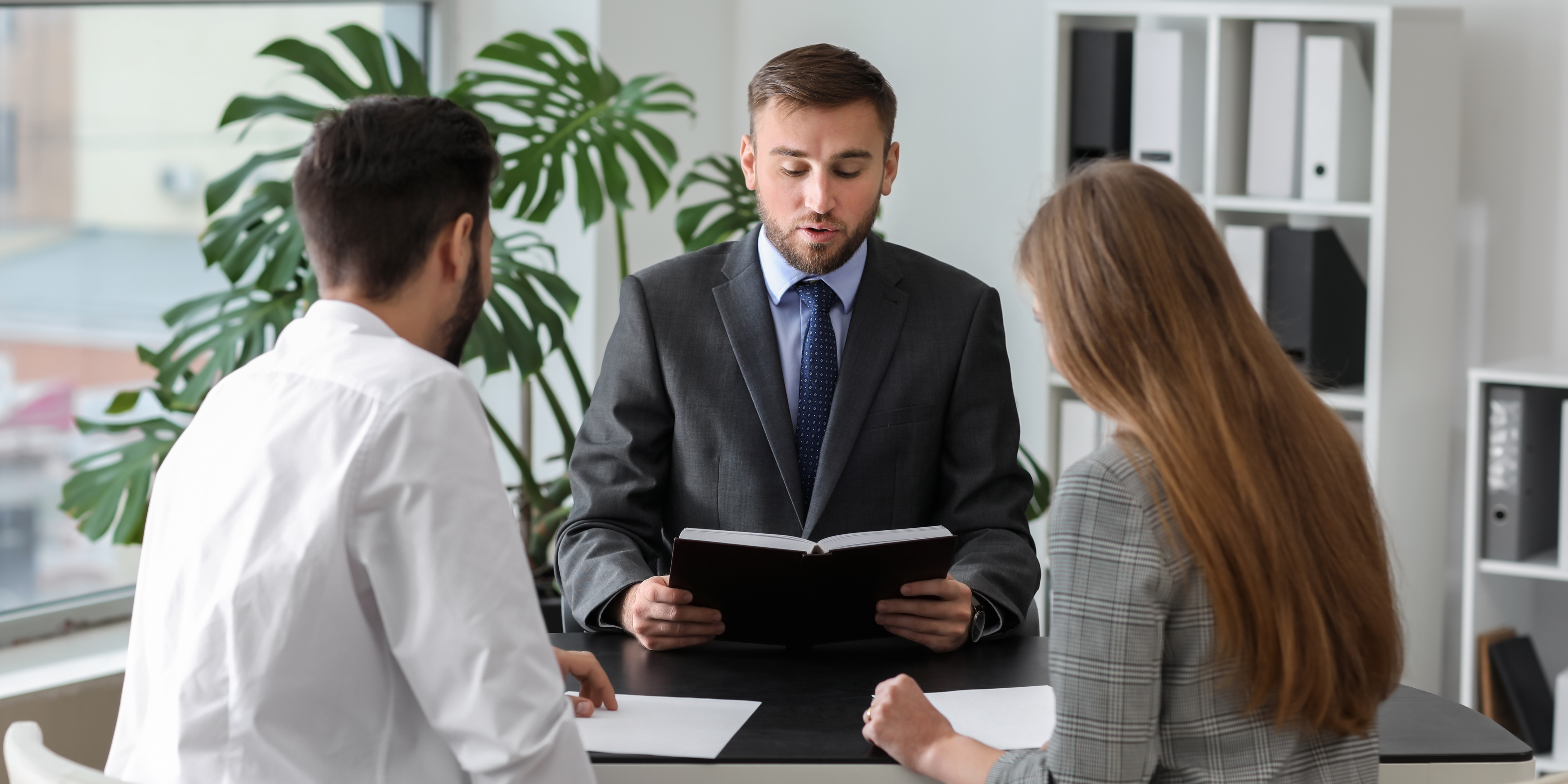 Couple meeting with a professional mediator in an office setting, discussing divorce terms calmly and collaboratively.