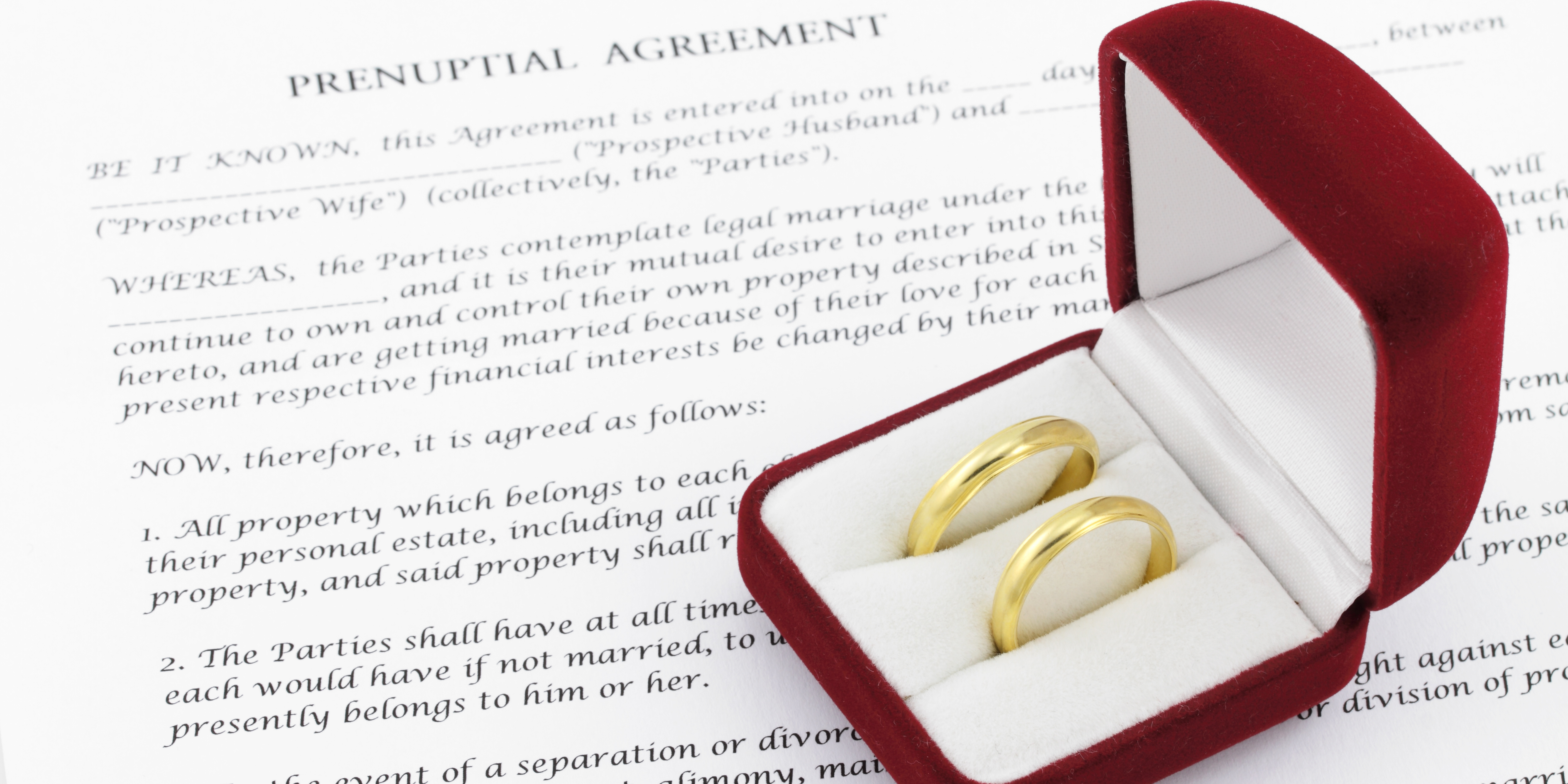 Wedding rings resting on a prenuptial agreement, representing prenups and postnuptial agreements in marriage planning