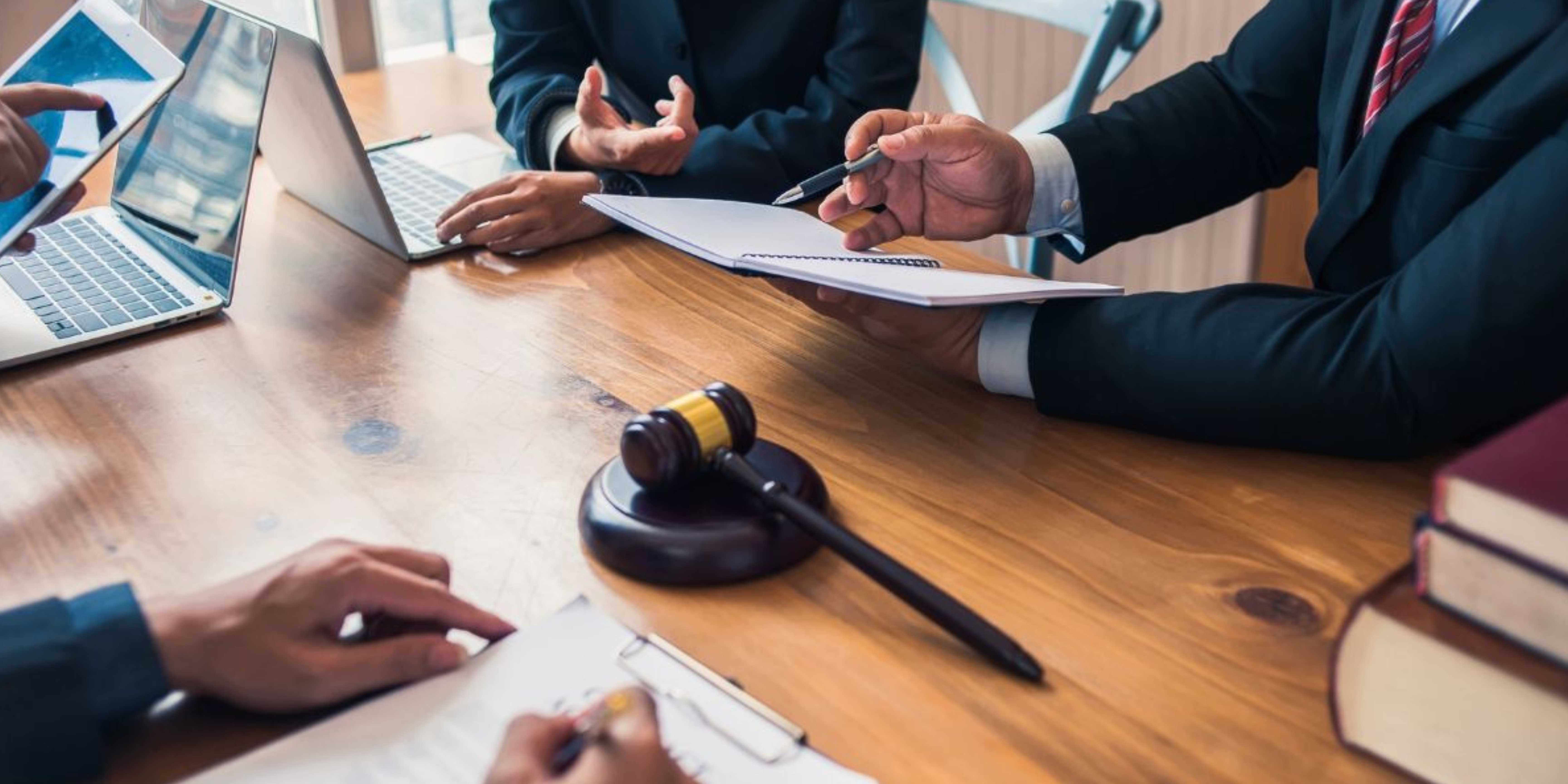 Image of Table Where Hands Are Discussing, Gavel In the Middle of The Table