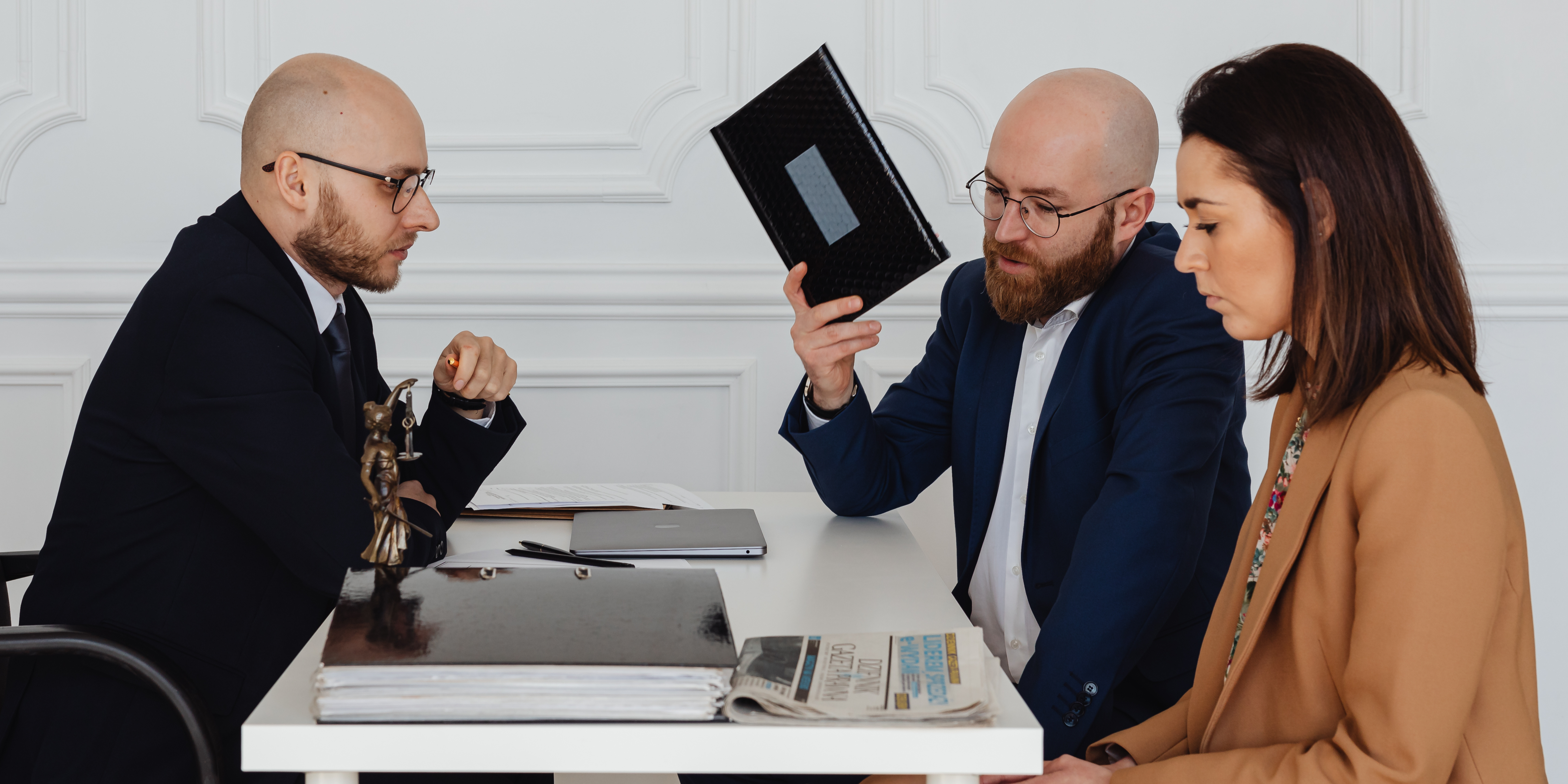 Two professionals consulting with a divorcing couple in a formal office setting.