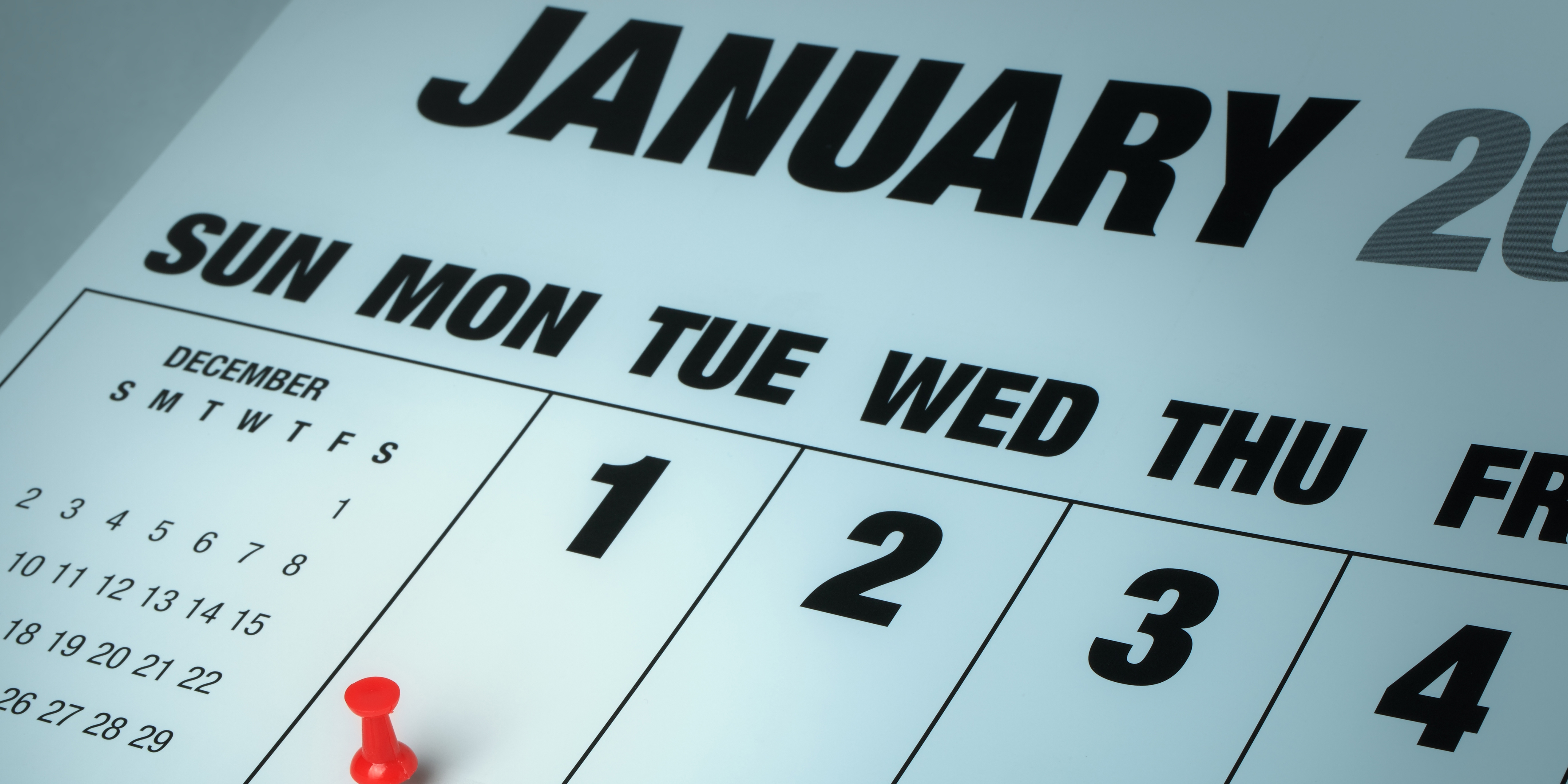 Close-up of a January calendar with a red pushpin marking the first week of the new year, symbolizing reflection, resolutions, and major life decisions like divorce.