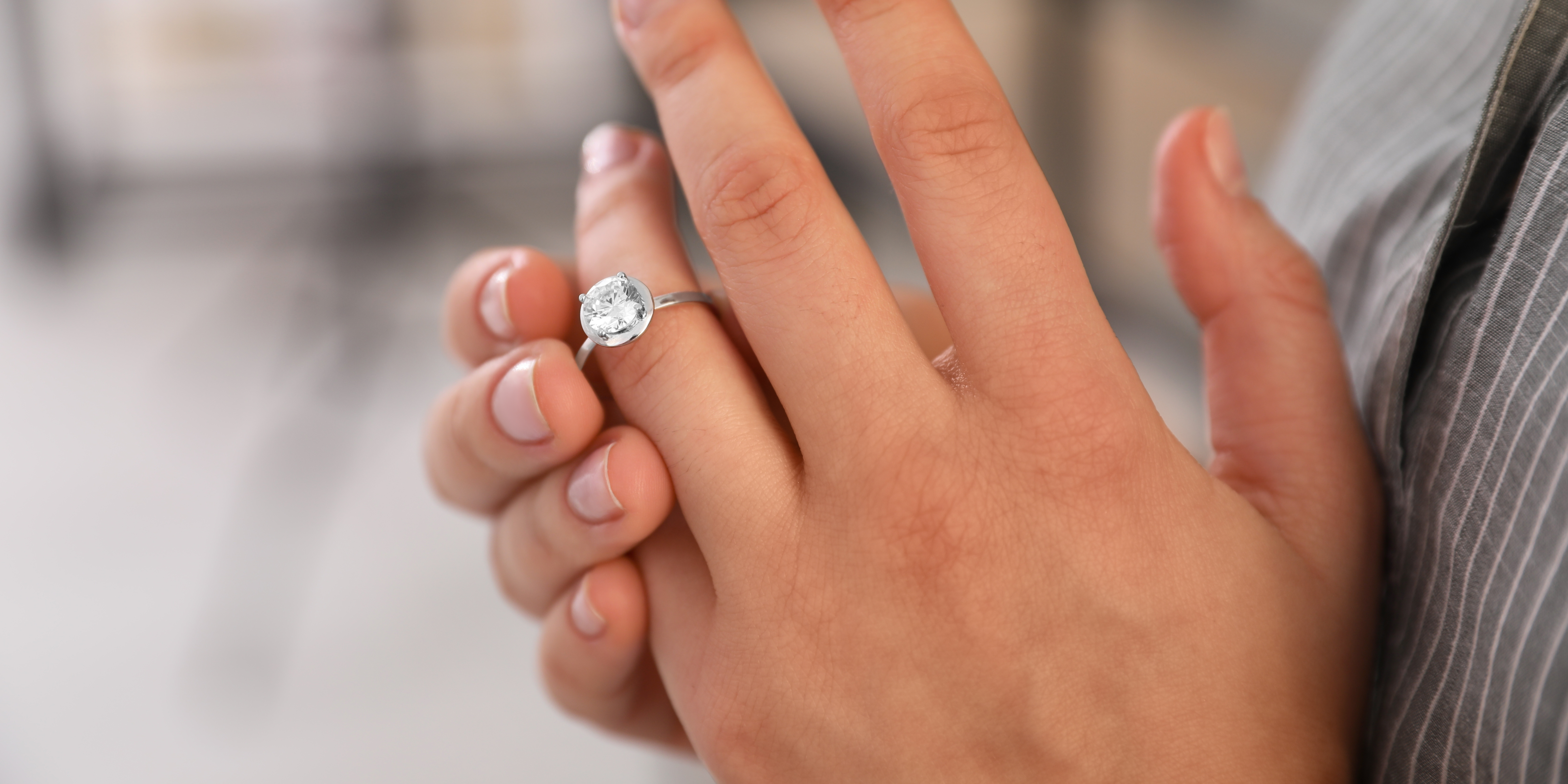 A close-up of a hand wearing an engagement ring, symbolizing someone contemplating divorce.
