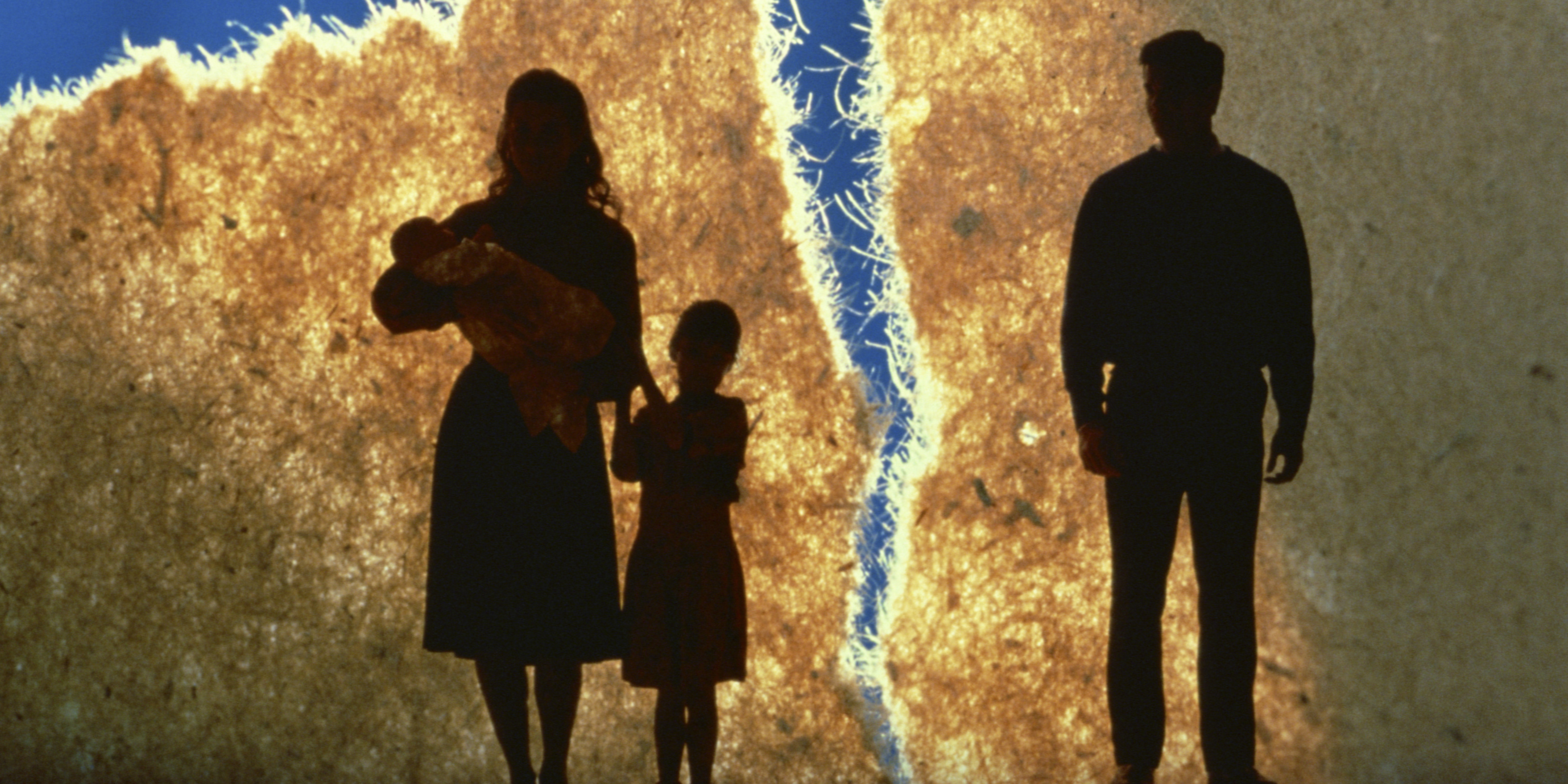Silhouetted family separated by a crack, representing blended family conflict and tension after divorce